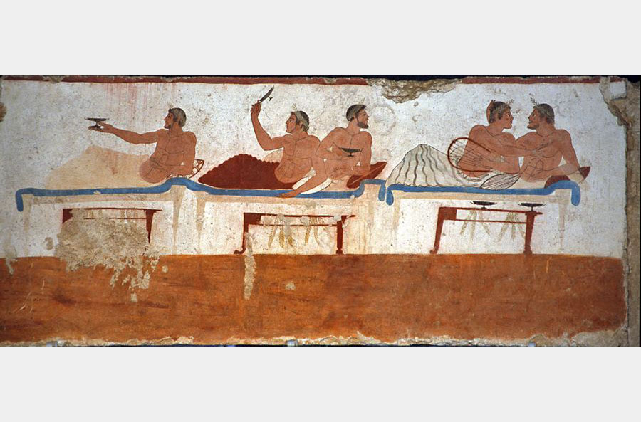 figure maschili inghirlandate e stese sui letti triclinari